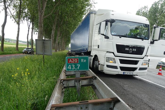 Bestelbus belandt op zijn kant, vrachtwagen ramt vangrail