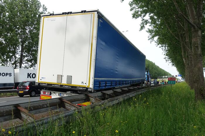Bestelbus belandt op zijn kant, vrachtwagen ramt vangrail