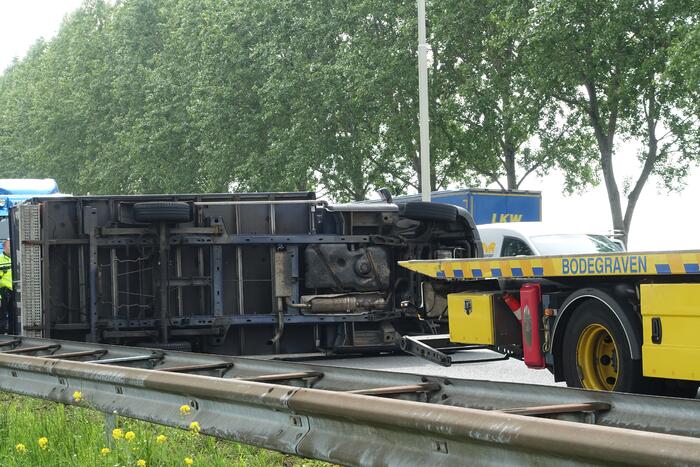 Bestelbus belandt op zijn kant, vrachtwagen ramt vangrail