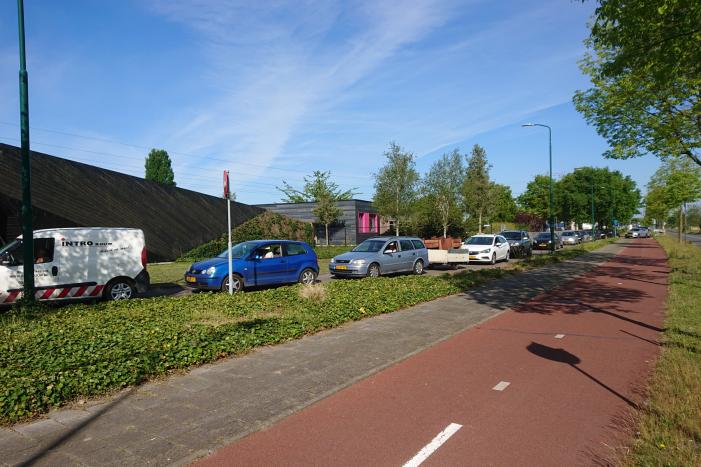 Wachtrij op fietspad bij vuilstort