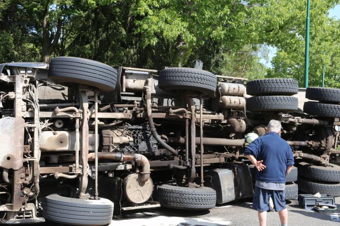 Vrachtwagen met tuinafval gekanteld op rotonde