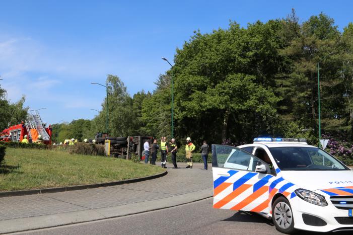 Vrachtwagen met tuinafval gekanteld op rotonde