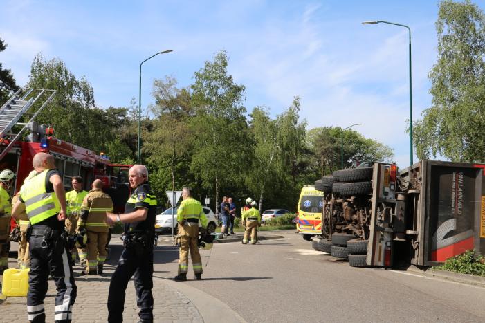 Vrachtwagen met tuinafval gekanteld op rotonde