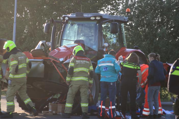 Scooter en scooterrijder bekneld onder tractor na ongeval