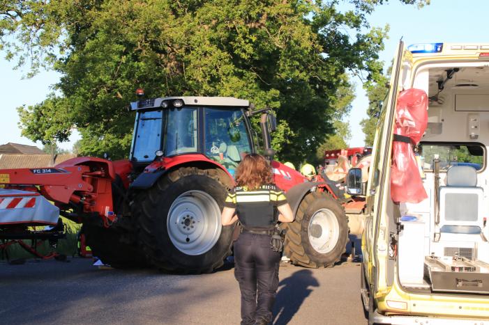 Scooter en scooterrijder bekneld onder tractor na ongeval