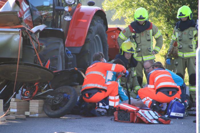 Scooter en scooterrijder bekneld onder tractor na ongeval