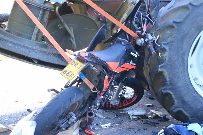 Scooter en scooterrijder bekneld onder tractor na ongeval