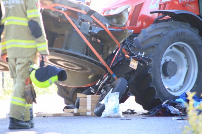 Scooter en scooterrijder bekneld onder tractor na ongeval