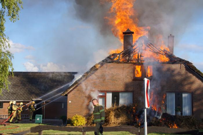 Rieten dak van woning volledig in brand