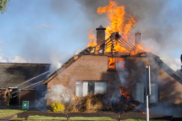 Rieten dak van woning volledig in brand