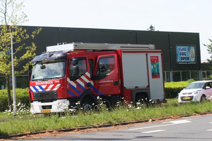 Brandweer blust brandend gras in berm