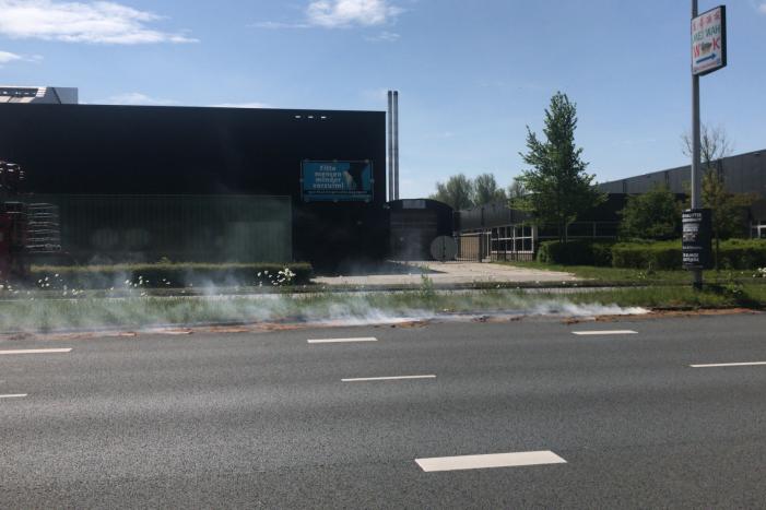 Brandweer blust brandend gras in berm