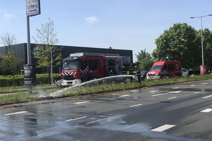 Brandweer blust brandend gras in berm