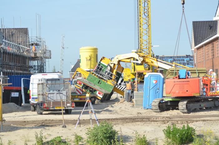 Vrachtwagen zakt door stempel bouwterrein