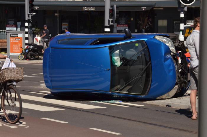Auto crasht en belandt op zijn kant