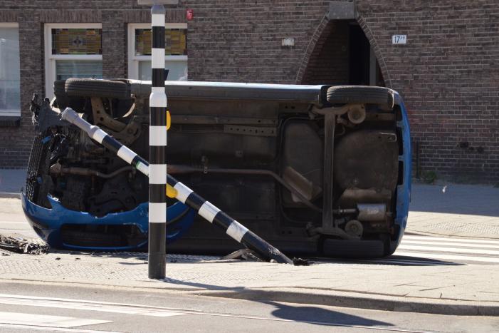 Auto crasht en belandt op zijn kant