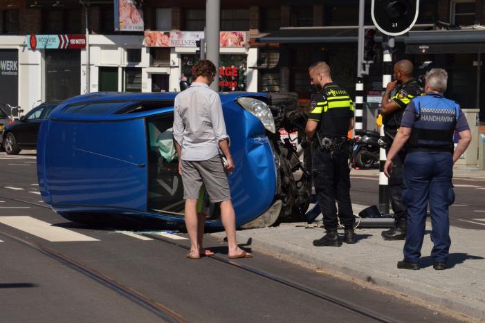 Auto crasht en belandt op zijn kant