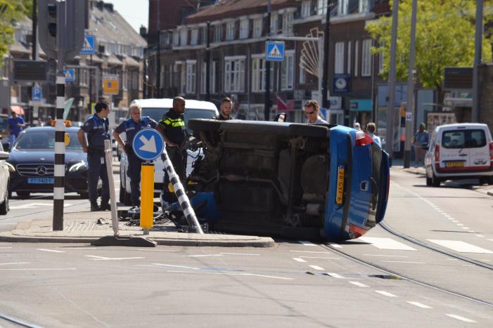 Auto crasht en belandt op zijn kant