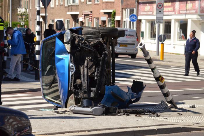 Auto crasht en belandt op zijn kant