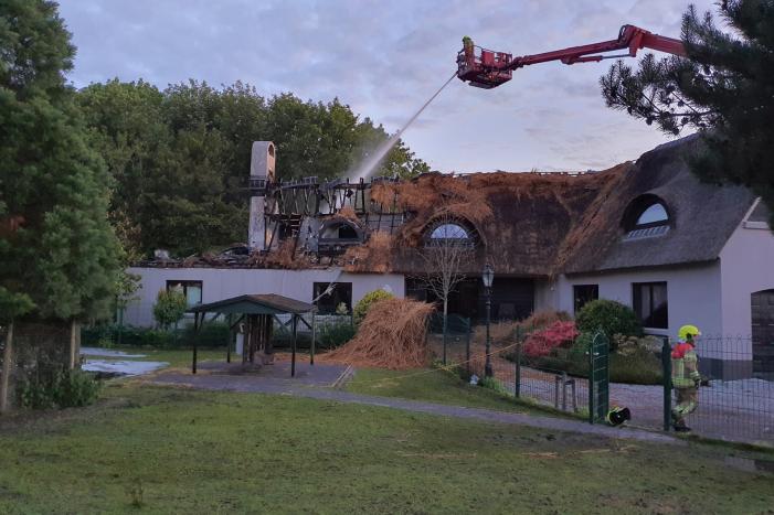 Ravage na brand in rietgedekt dak van woning