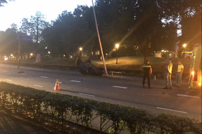 Auto knalt op lantaarnpaal en belandt op de kop