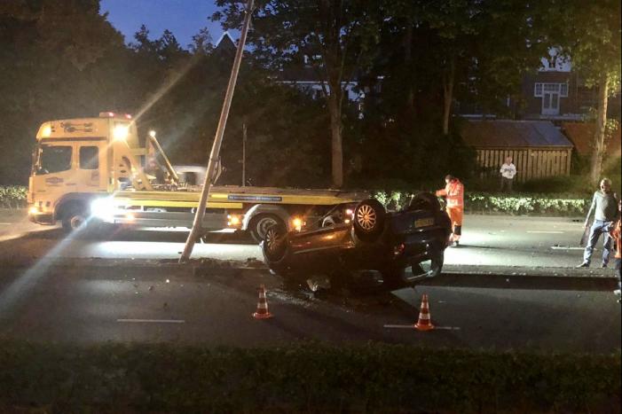 Auto knalt op lantaarnpaal en belandt op de kop