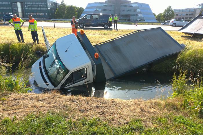 Bestelbus op zijn kant autoambulance in de sloot