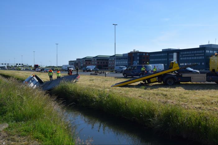 Bestelbus op zijn kant autoambulance in de sloot