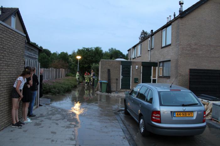 Groot sinkhole en straat vol water na leidingbreuk