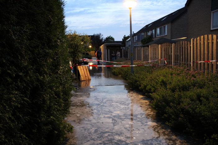 Groot sinkhole en straat vol water na leidingbreuk