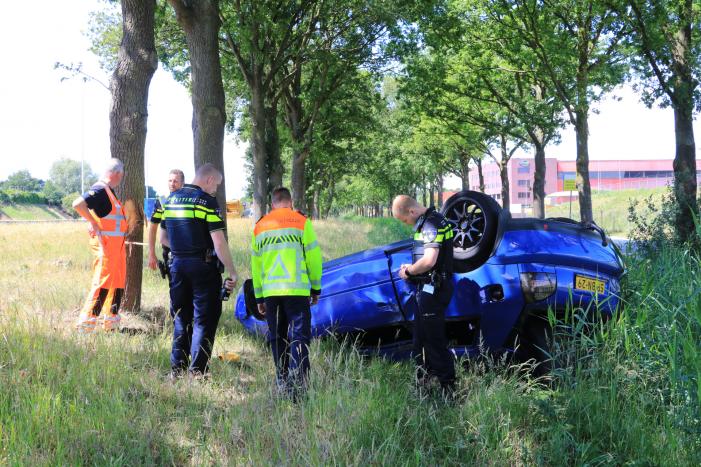 Auto raakt van snelweg en belandt op de kop