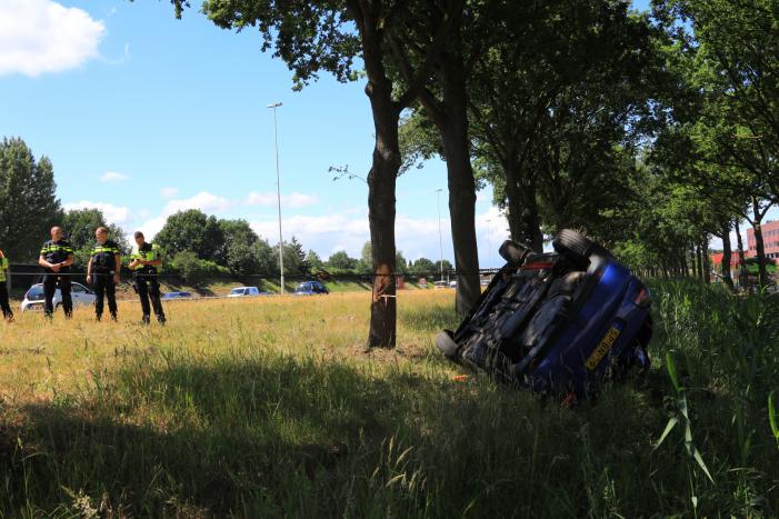 Auto raakt van snelweg en belandt op de kop