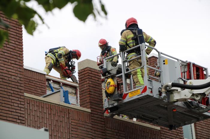 Gloednieuw dak van woning opengezaagd na brand