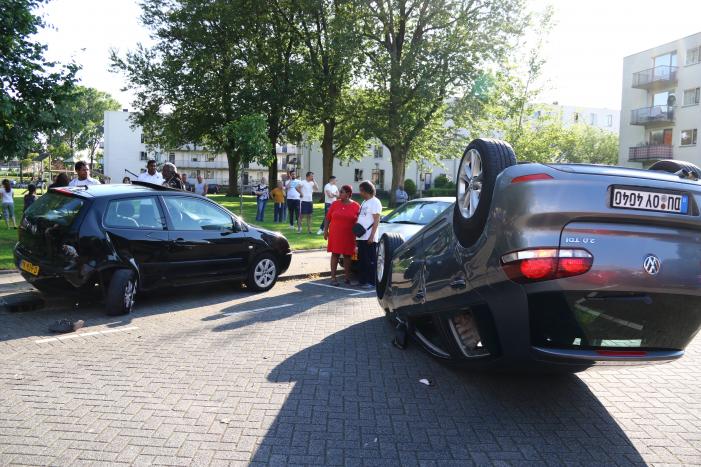 Auto op zijn kop na aanrijding met geparkeerde auto