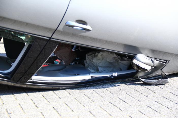 Auto op zijn kop na aanrijding met geparkeerde auto