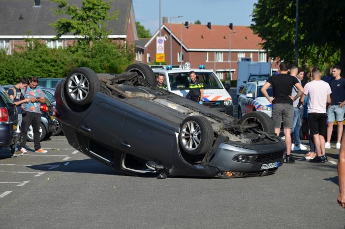 Auto op zijn kop na aanrijding met geparkeerde auto