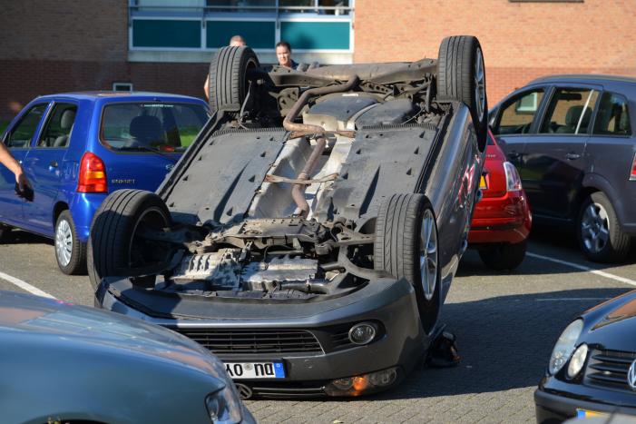 Auto op zijn kop na aanrijding met geparkeerde auto