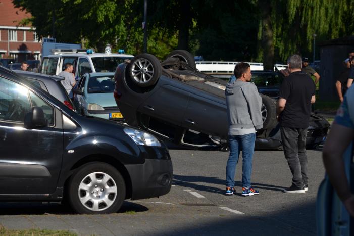 Auto op zijn kop na aanrijding met geparkeerde auto