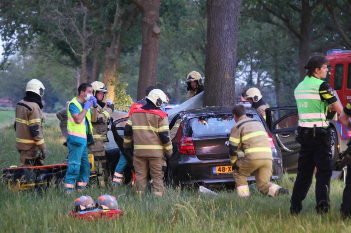 Bestuurder bekneld bij botsing tegen boom
