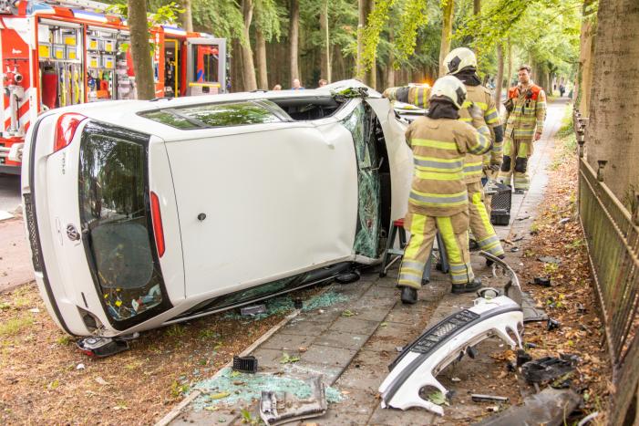 Auto crasht belandt op zijkant, bestuurder slaat op de vlucht