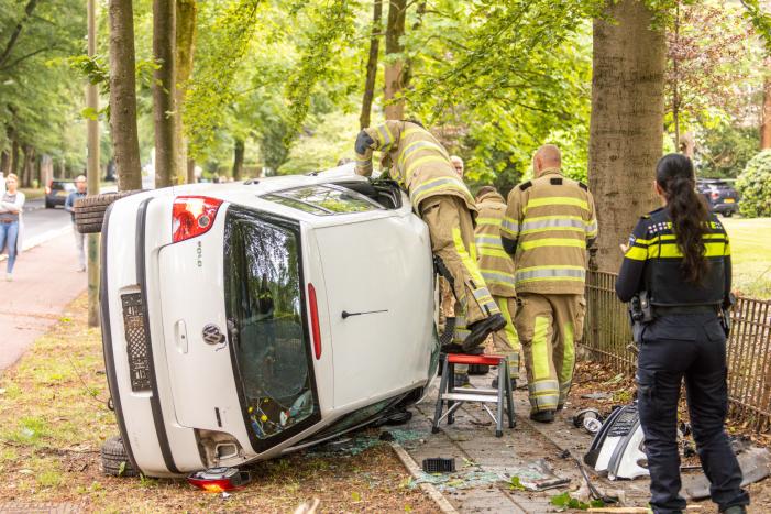 Auto crasht belandt op zijkant, bestuurder slaat op de vlucht
