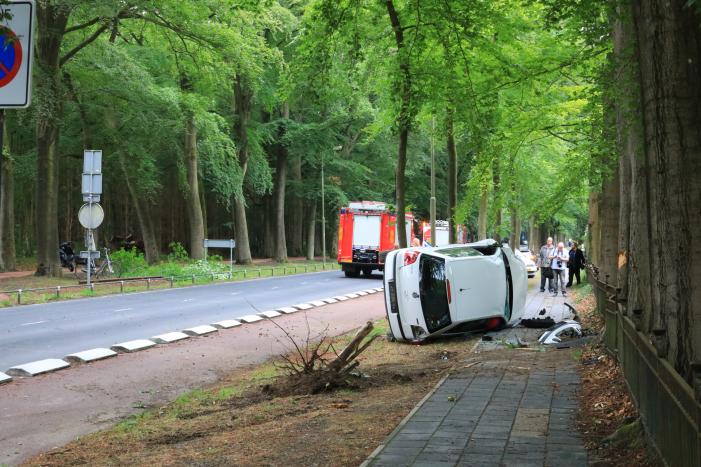 Auto crasht belandt op zijkant, bestuurder slaat op de vlucht