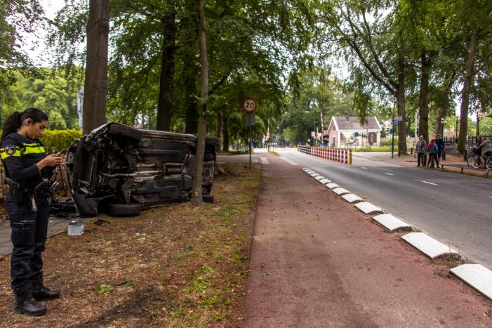 Auto crasht belandt op zijkant, bestuurder slaat op de vlucht