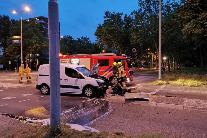 Bestelbus rijdt verkeerslicht uit de grond