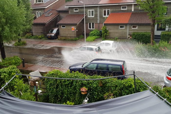 Straat onder water na wolkbreuk
