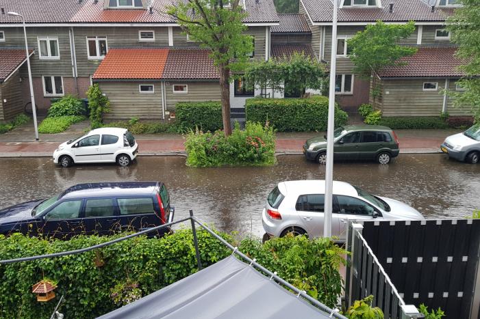 Straat onder water na wolkbreuk