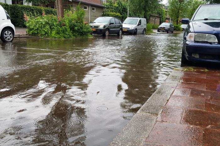 Straat onder water na wolkbreuk