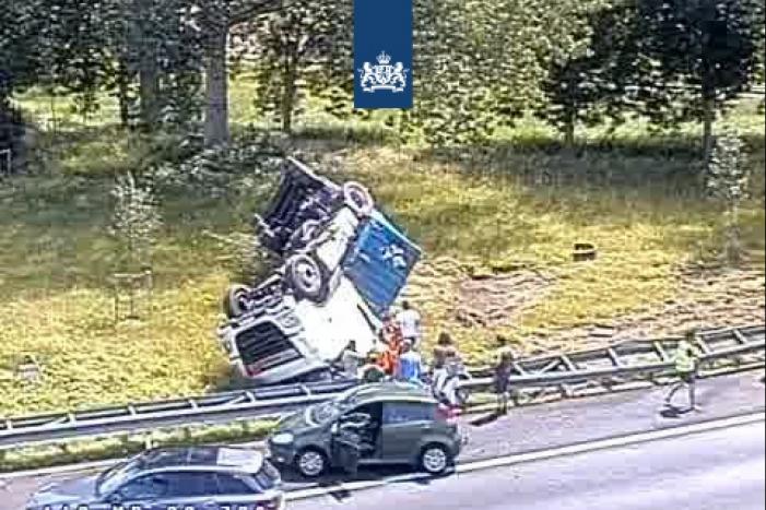Vrachtwagen op de kop in de berm na aanrijding