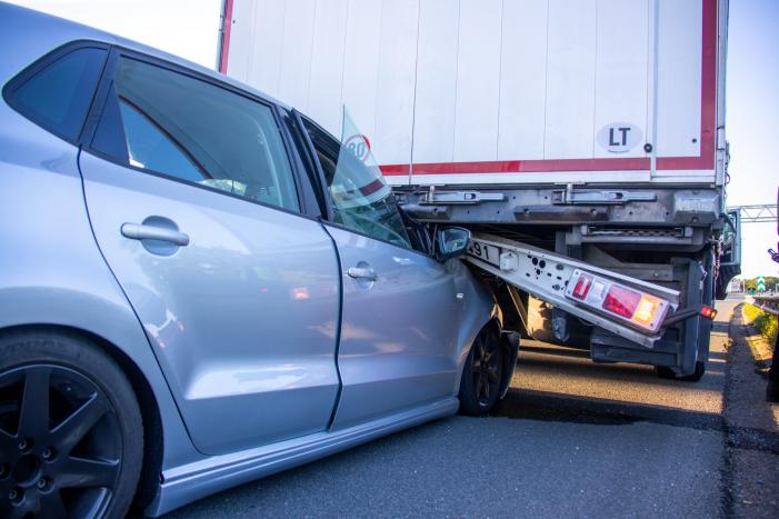 Auto schiet onder oplegger vrachtwagen