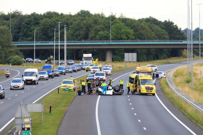 Auto op de kop na aanrijding op snelweg